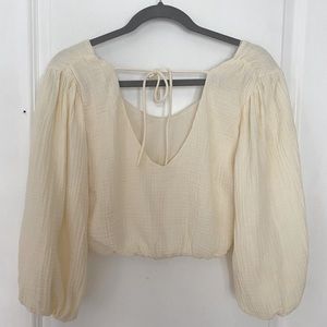 Off white cropped top, long puffy sleeves, open back with tie, fitted bottom